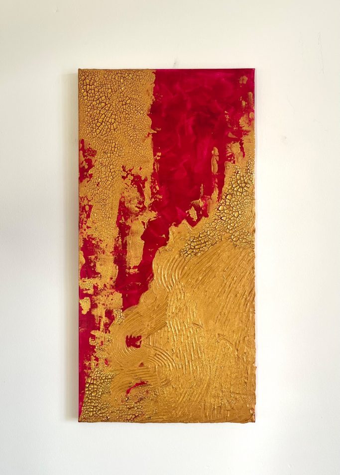 Abstrakte Wanddekoration in Gold und Rot mit strukturiertem Muster.